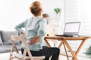Woman in pain working at dining room table