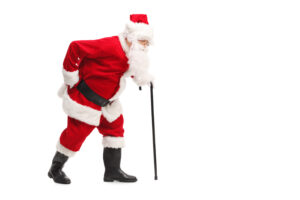 Santa with back pain walking with cane